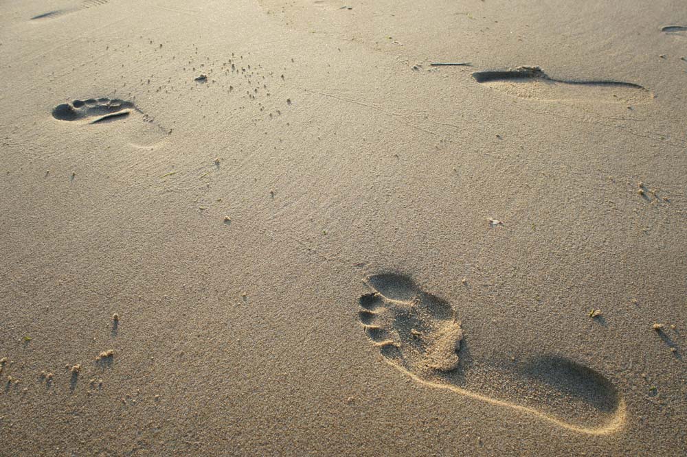 Fussspuren im Sand von rechts nach links